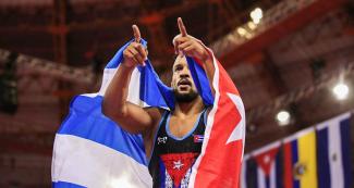 Alejandro Valdes celebrates with the Cuban flag his victory against Dominican Albaro Rudesindo at the Callao Regional Sports Village at Lima 2019