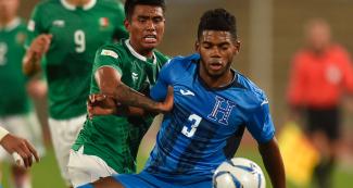 Elvin Oliva Casildo of Honduras and Pablo César López of Mexico challenge for the ball in the Lima 2019 football semifinal at the San Marcos Stadium