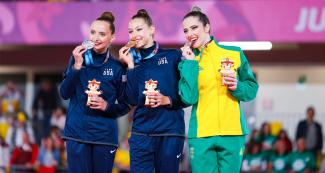 Camila Feeley de EEUU (plata), Evita Griskenas de EEUU (oro) y Natalia Gaudio de Brasil (bronce) lucen orgullosas sus medallas de la categoría individual de gimnasia rítmica en los Juegos Lima 2019 en el Polideportivo Villa el Salvador.