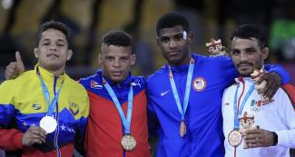 Proud athletes from Venezuela (silver), Cuba (gold) and Mexico (bronze) show their medals after competing in Greco-Roman wrestling at the Callao Regional Sports Village