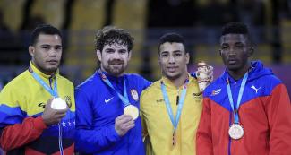 Proud athletes from Venezuela (silver), USA (gold), Colombia and Cuba (bronze) show their medals after competing in Greco-Roman wrestling at the Callao Regional Sports Village