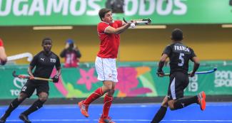 José Maldonado from the Chilean hockey team and the Trinidad and Tobago team members competing for the ball at the Villa María del Triunfo Sports Center