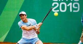 Argentinian Facundo Bagnis hits the ball during Lima 2019 tennis match against his compatriot Guido Andreozzi at Club Lawn Tennis