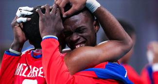 Osniel Melgarejo from Cuba and his teammate celebrate with a hug after winning the volleyball match against Brazil at Lima 2019 Games