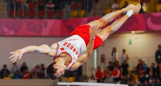 Rene Cournoyer de Canadá vuela por los aires en competencia de gimnasia artística masculina, en los Juegos Lima 2019 en el Polideportivo Villa el Salvador