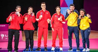 Brazilian, Cuban and Canadian teams posing with their Lima 2019 mixed doubles Para badminton SL3-SU5 bronze, silver and gold medals, respectively, at the Villa El Salvador Sports Center.