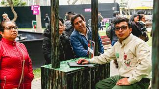 Voluntario de Sernanp ofrece información a personas que se acercaron al módulo de la herramienta de huella de carbono, en los Juegos Lima 2019.