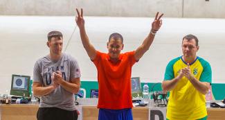 Jorge Grau from Cuba (gold), Nickolaus Mowrer from the USA (silver) and Julio de Souza from Brazil (bronze) pose proudly after competing in men’s 10 m air pistol at Las Palmas Air Base.