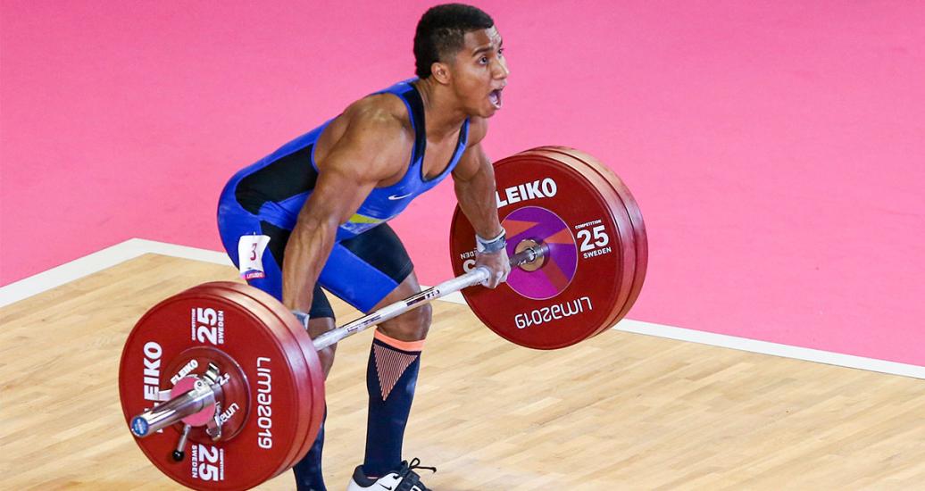 Atleta Jhon Serna sosteniendo las pesas en competencia 