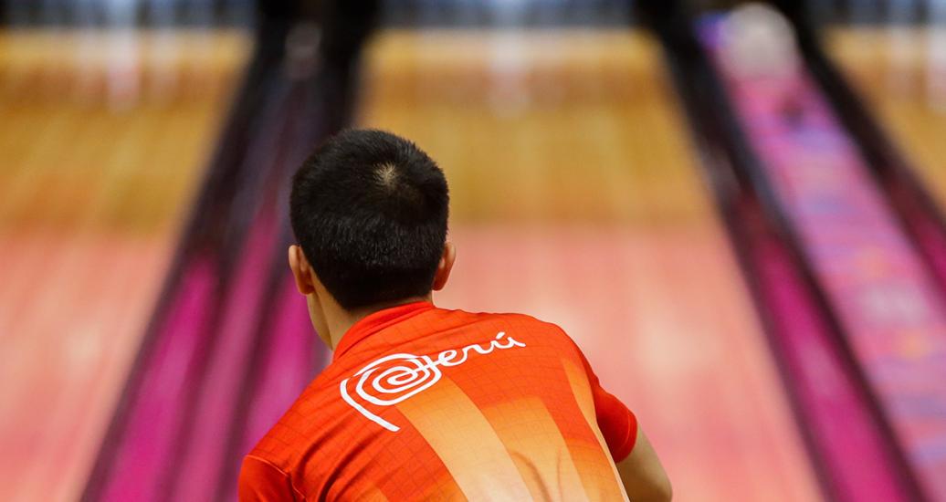 Alejandro Yum, from the Peruvian bowling team, throws a ball during the competition