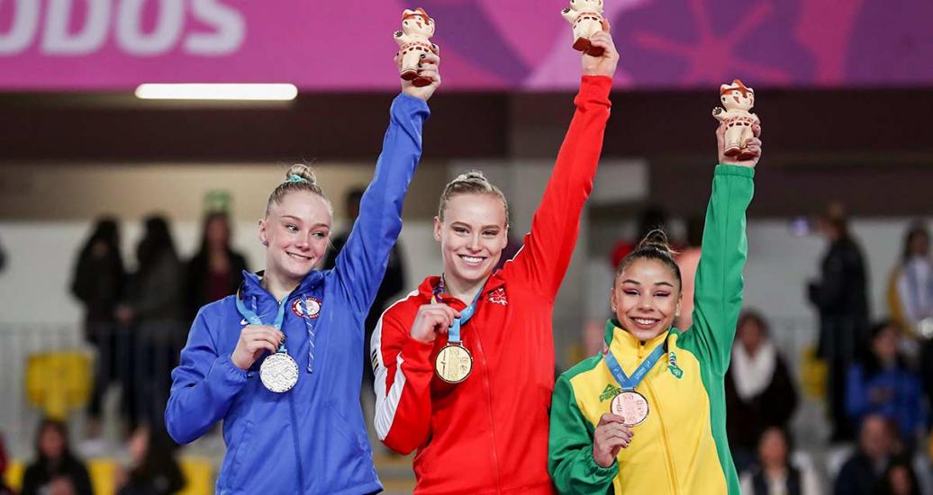 Riley MC Cusker, Elsabeth Black y Flavia Saraiva muestran medallas por su victoria en gimnasia artística en Lima 2019, en el Polideportivos de Villa El Salvador 