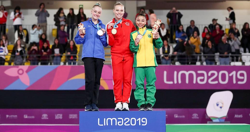Riley MC Cusker, Elsabeth Black and Flavia Saraiva show medals earned in artistic gymnastics at Lima 2019  