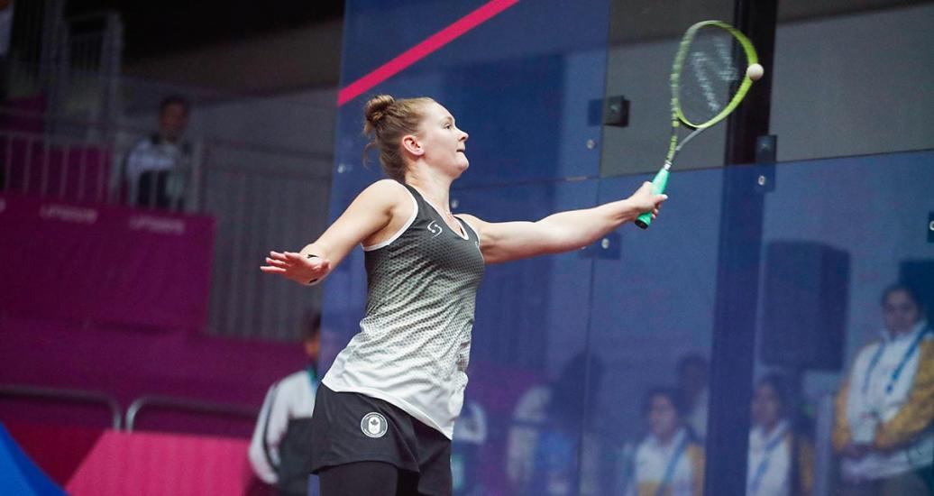 Hollie Laughton receives squash ball with racket