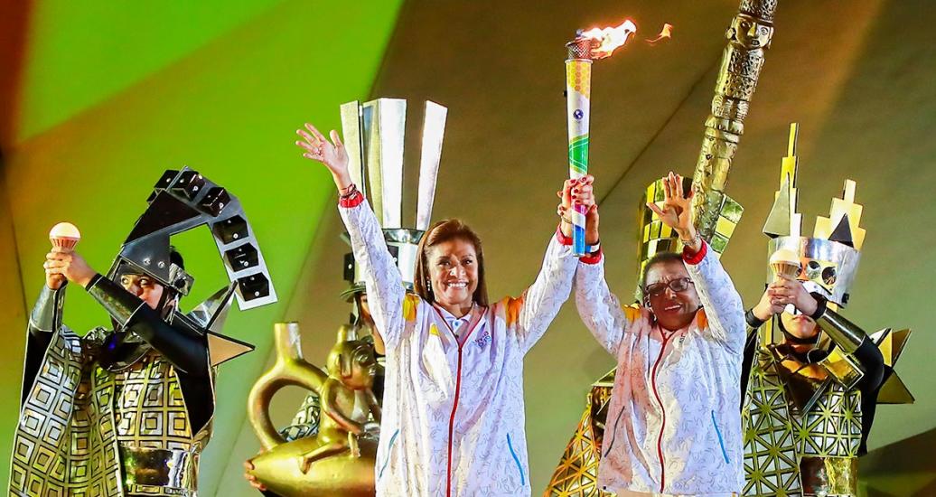 Volleyball players Cecilia Tait and Lucha Fuentes holding the Pan American Torch