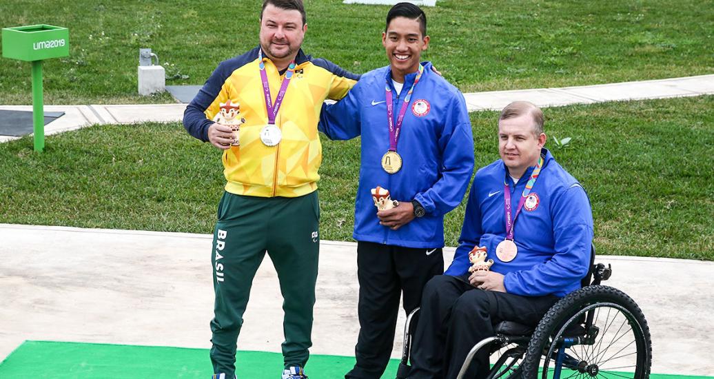 Robert Beach de EE. UU. (bronce), Carlos Garletti de Brasil (plata) y Kevin Nguyen de EE. UU. (oro) posan orgullosos con sus medallas de 50 m rifle tendido, en Lima 2019 en la Base Aérea Las Palmas