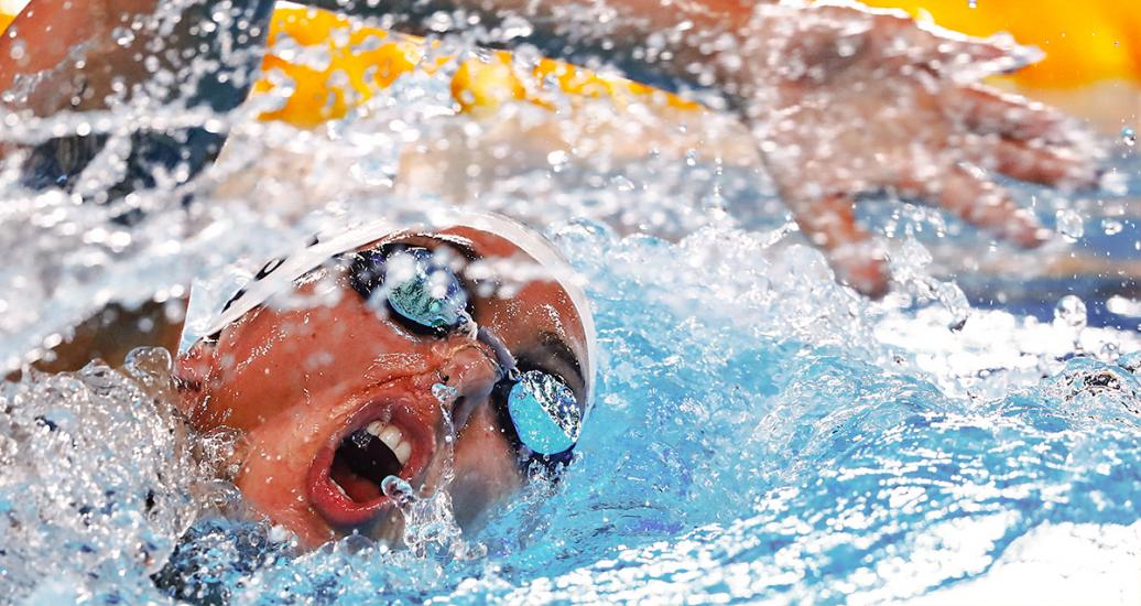 Nadadora, Florencia Perotti, respira por la boca mientras hace una brazada al estilo libre, el agua salpica por todas partes, en la Villa Deportiva Nacional – VIDENA