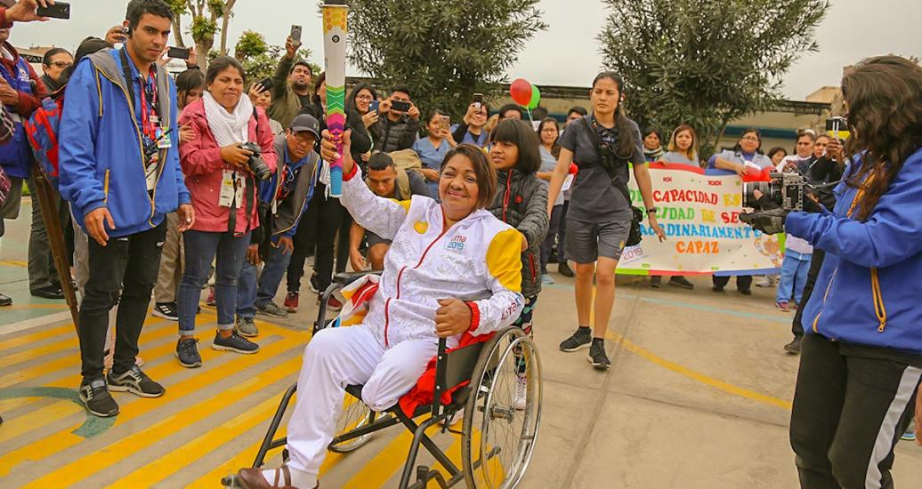 A torchbearer carries the torch in the air on the third day of the Lima 2019 Parapan American Torch Relay