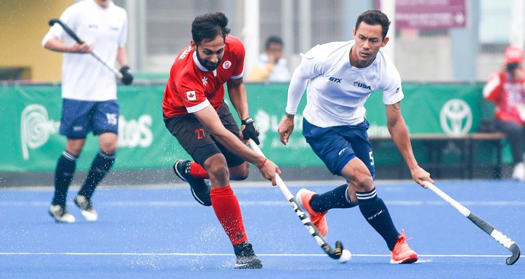 Canadian Sukhpal Panesar and American Patrick Harris fight for the ball during a hockey match held at the Villa María del Triunfo Sports Center at Lima 2019.