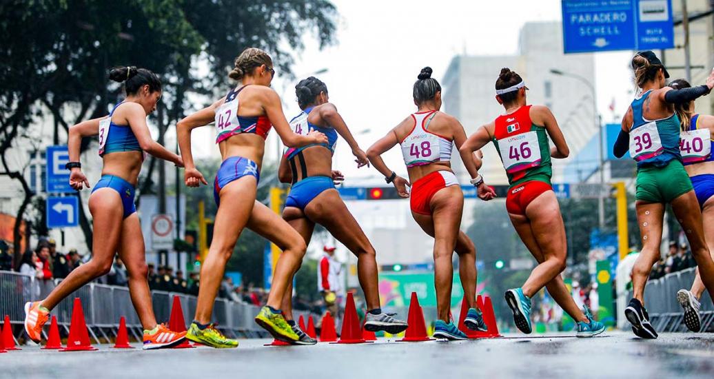 Athletes rounding the corner and doing their best to reach the finish line in the Lima 2019 race walking event at Parque Kennedy in Miraflores. 