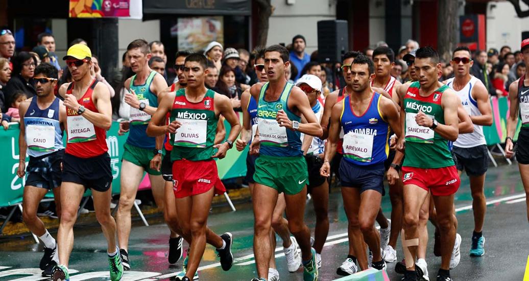 Grupo de atletas de marcha atlética de distintos países esforzándose paso a paso, en los Juegos Lima 2019, en el Parque Kennedy de Miraflores.
