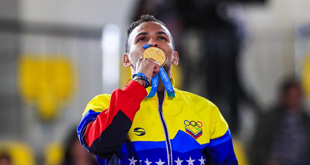 André Madera from Venezuela kisses the gold medal he won in the Lima 2019 Pan American Games karate kumite competition, at the Villa María del Triunfo Sports Center.