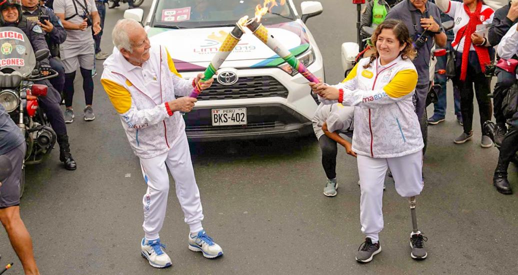Lima 2019 Parapan American flame is carried by two flagbearers during the torch route