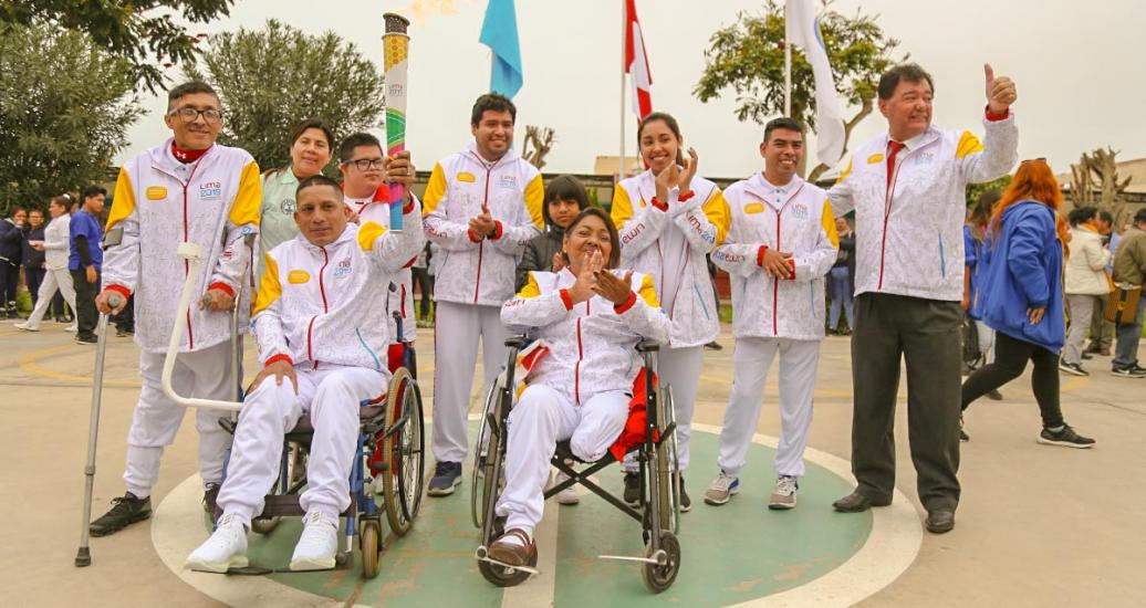 Un grupo de portadores de antorcha, incluyendo algunos Para deportistas, posan orgullosos con la antorcha en el aire en el tercer día del Relevo de la Antorcha Parapanamericana de Lima 2019