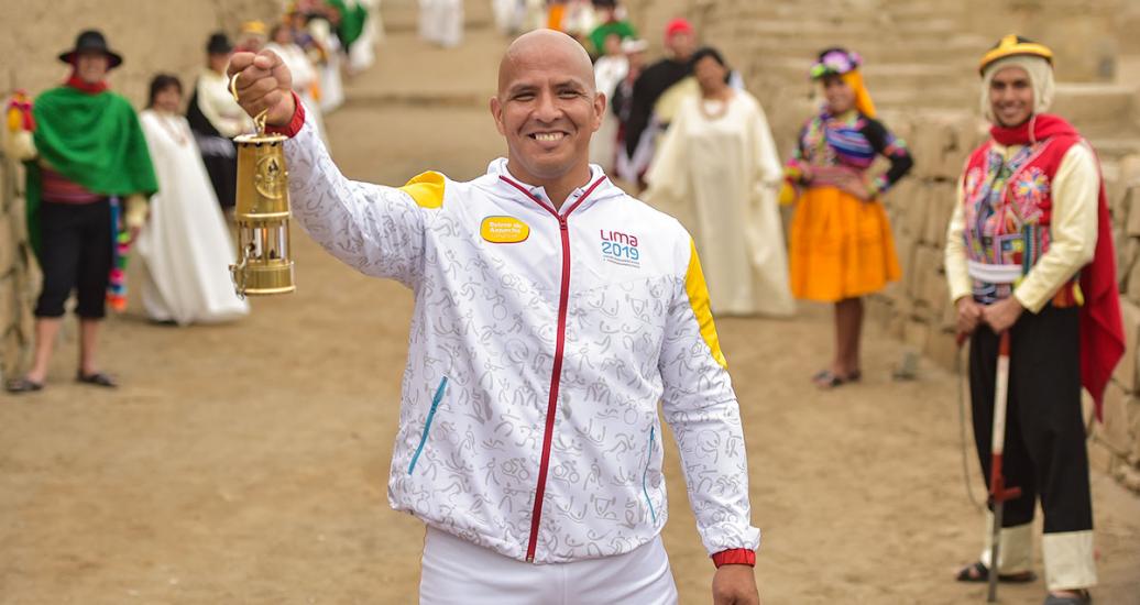 Para athlete Carlos Felipe smiles proudly while raising the Lima 2019 Parapan American Torch in Pachacamac.