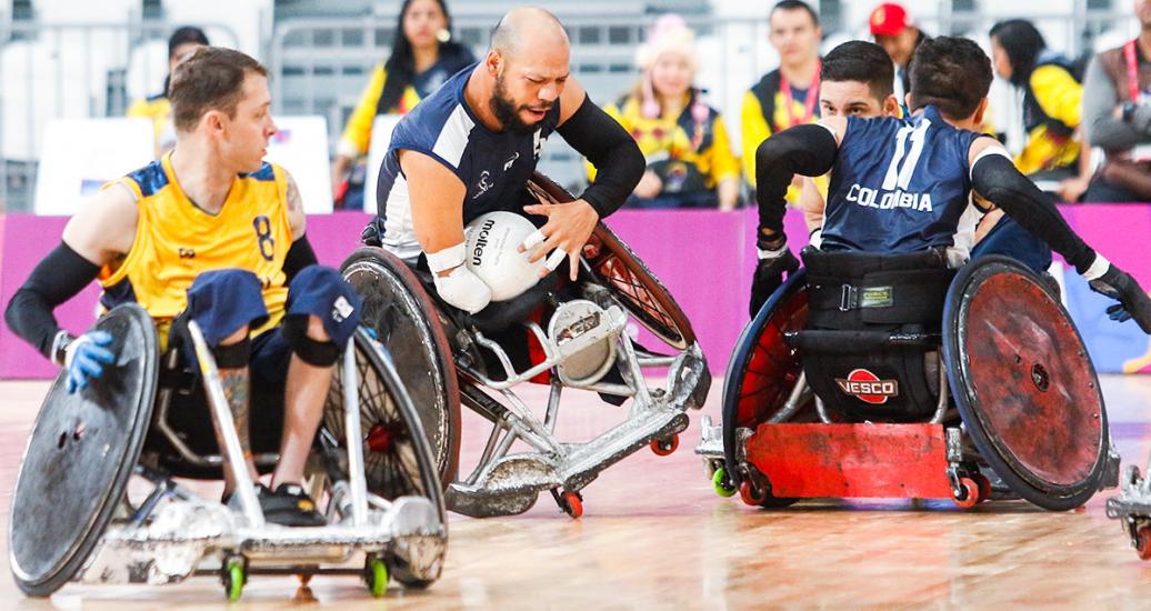 Juan Orozco (Colombia) protegiendo el balón mientras está a punto de caerse durante partido de rugby en silla de ruedas en los Juegos Parapanamericanos Lima 2019. 