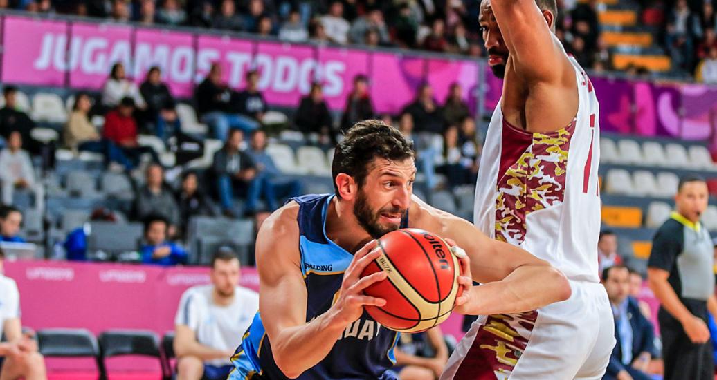 Uruguayan Nicolas Borsellino fights for the basketball against Venezuelan Luis Bethelmy in the Lima 2019 basketball competition at Eduardo Dibós Coliseum