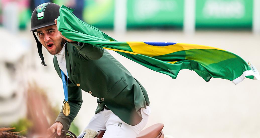 Marlon Zanotelli de Brasil celebra el oro con una bandera de su país en los Juegos Lima 2019 en la Escuela de Equitación del Ejército