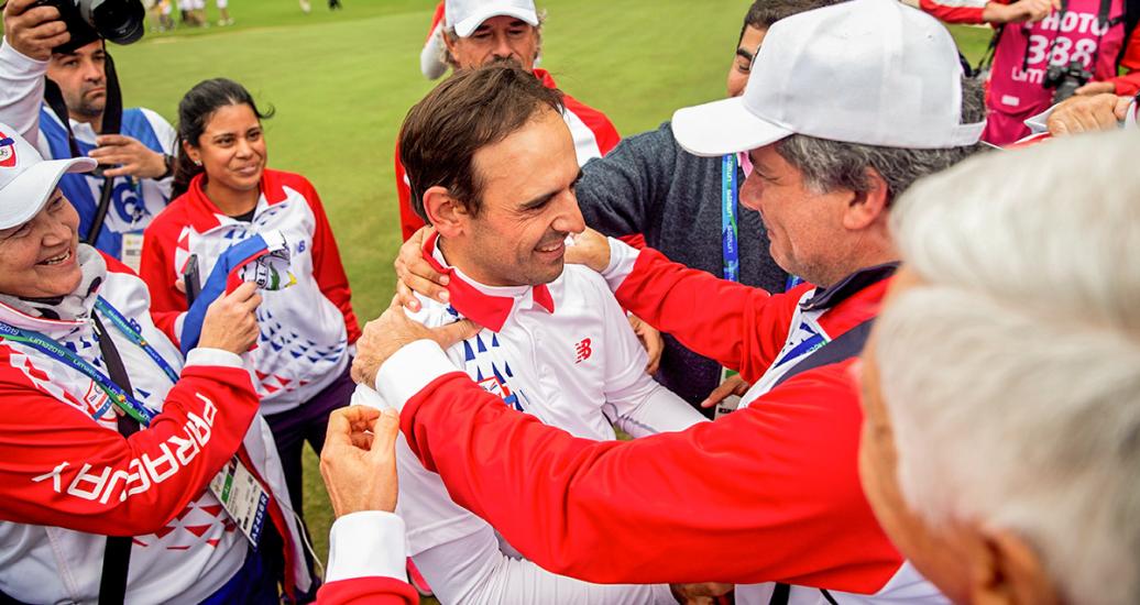 Fabrizio Zanotti from Paraguay celebrates his gold medal in the Lima 2019 golf competition with his team at the Lima Golf Club