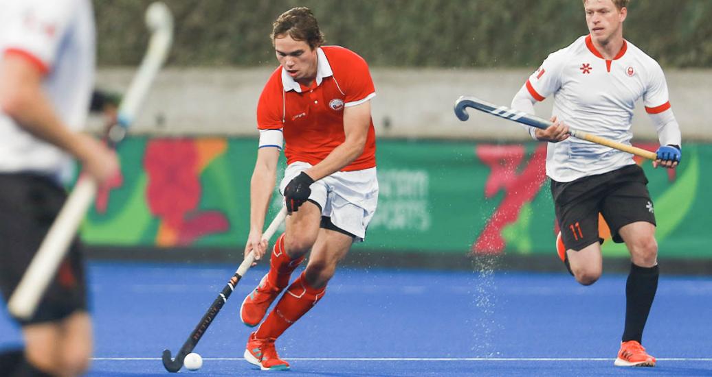 Chilean Fernando Renz steals the ball from Canadian Singh Panesar at hockey semifinal at Villa María del Triunfo Sports Center, Lima 2019 Games