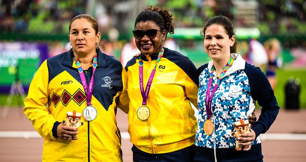 Izabela Silva from Brazil (gold), Yesenia Restrepo from Colombia (silver) and Florencia Romero from Argentina (bronze) pose proudly with their discus throw F11 medals at the National Sports Village - VIDENA