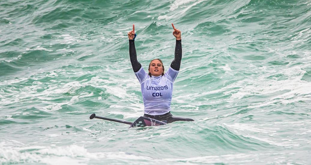 Isabela Gomez de Colombia hace un gesto desde su tabla en competencia de surf SUP femenino, en los Juegos Lima 2019, en Punta Rocas