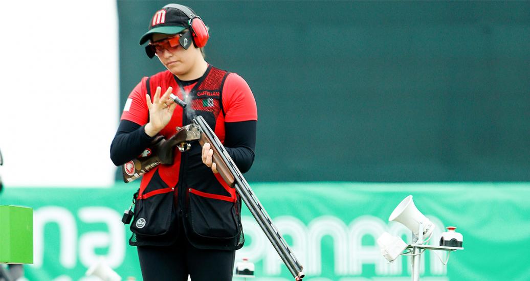 Alejandra Ramirez cargando su escopeta con balas para iniciar tiro, en Lima 2019