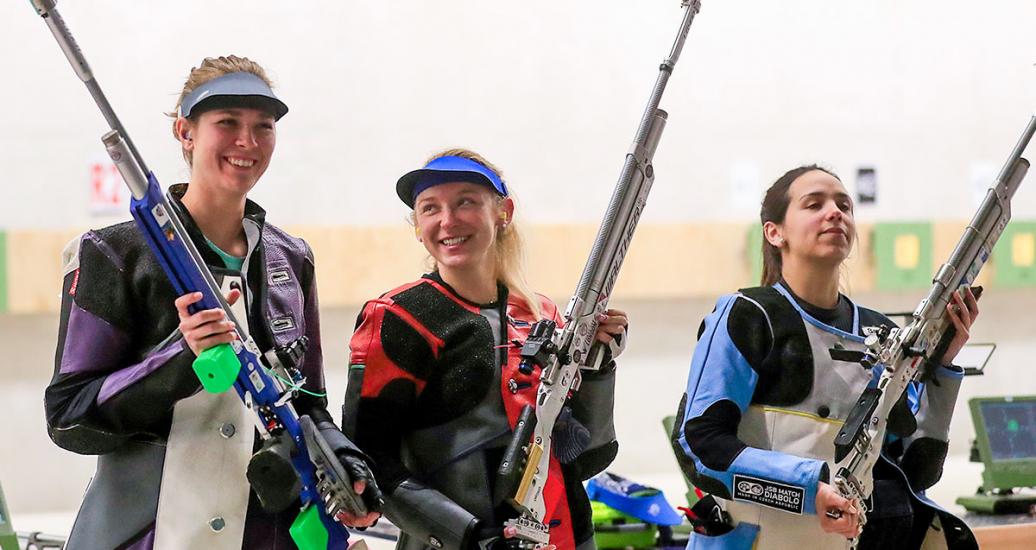 Medalists Miles Minden (USA), Alison Weisz (USA), and Fernanda Russo (Argentina) celebrate their medals and aim into the air with their rifles after the women’s 10 m air rifle event of the Lima 2019 Pan American Games at Las Palmas Air Base.