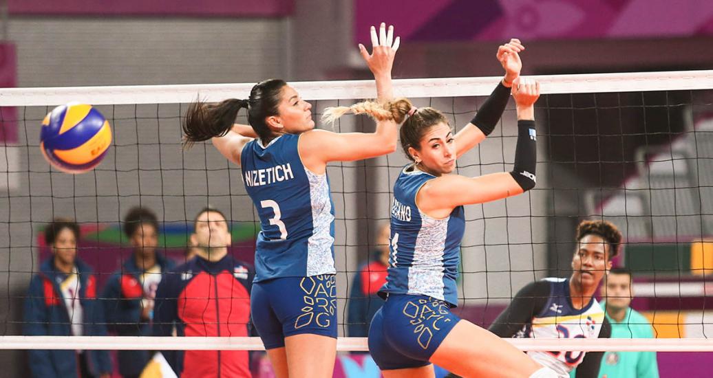 Yamila Nizetich y Constanza Lazcano realizan salto en defensa de parcela Argentina durante partido de vóleibol, en los Juegos Lima 2019, en la Villa Deportiva Regional del Callao