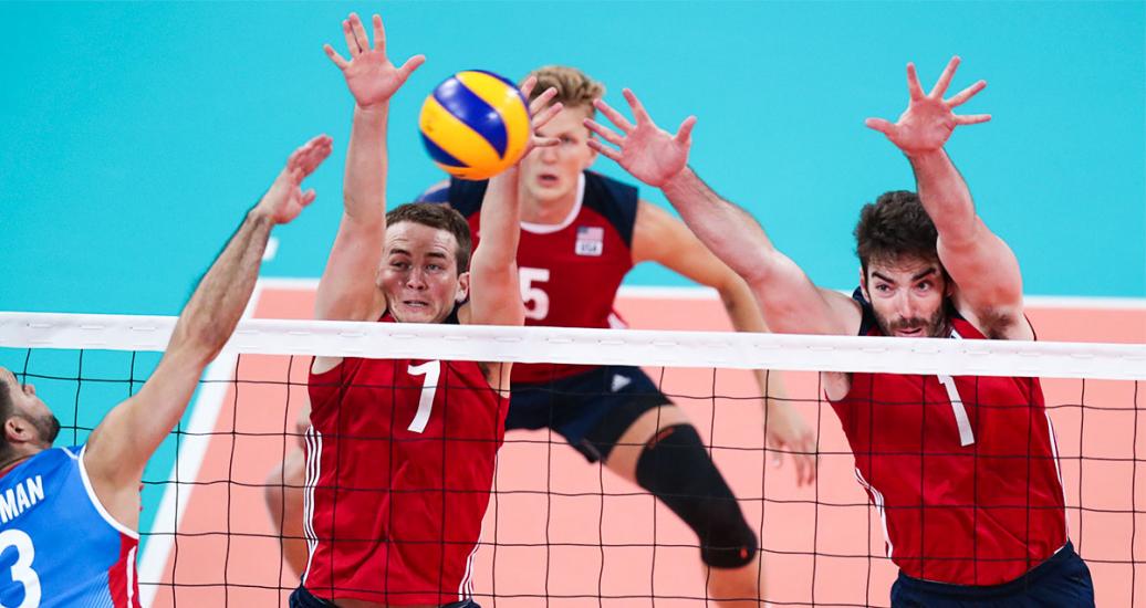 Puerto Rican volleyball player Pablo Guzmán fights for the ball against american players Joseph Worsley and Thomas Carmody during the Lima 2019 match at the Callao Regional Sports Village