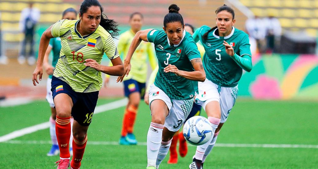 Mayra Ramirez de Colombia y Bianca Sierra de México se disputan el balón de fútbol en la competencia de los Juegos Lima 2019 en el Estadio San Marcos.