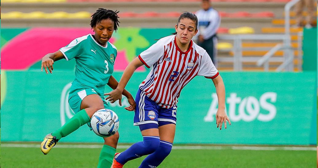 La futbolista jamaiquina, Chanel Hudson, disputa el balón con María Martinez de Paraguay durante la primera ronda de fútbol femenino, en los Juegos Lima 2019, en el Estadio San Marcos