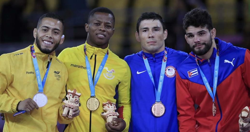 Proud athletes from Colombia (silver), Ecuador (gold) and USA (bronze) show their medals after competing in Greco-Roman wrestling at the Callao Regional Sports Village