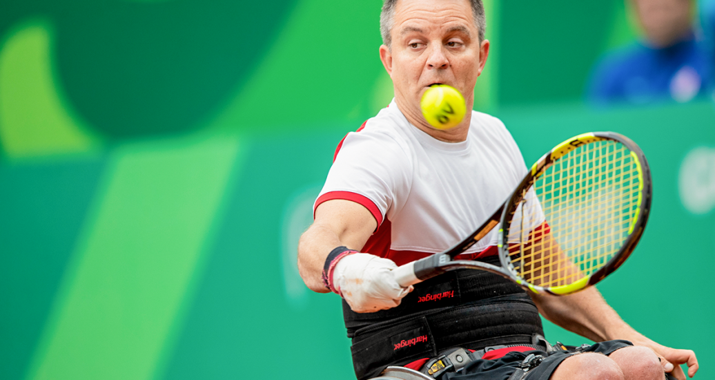 Bryan Barten de EE. UU. con la pelota en partido de tenis en silla de ruedas contra Canadá en Lima 2019 en el Club Lawn Tenis