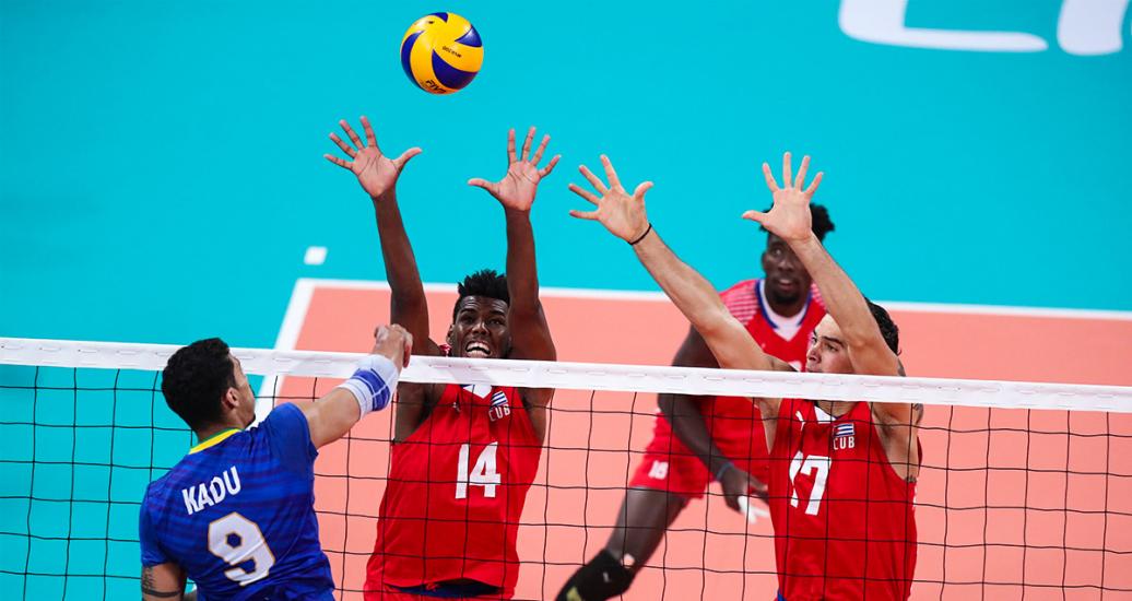 Brazil’s Carlos Barreto spikes the ball against Cuba’s Adrian Giode, Raul Alonso and Liván Osoria during the volleyball match in the Lima 2019 semifinal held at the Callao Regional Sports Village