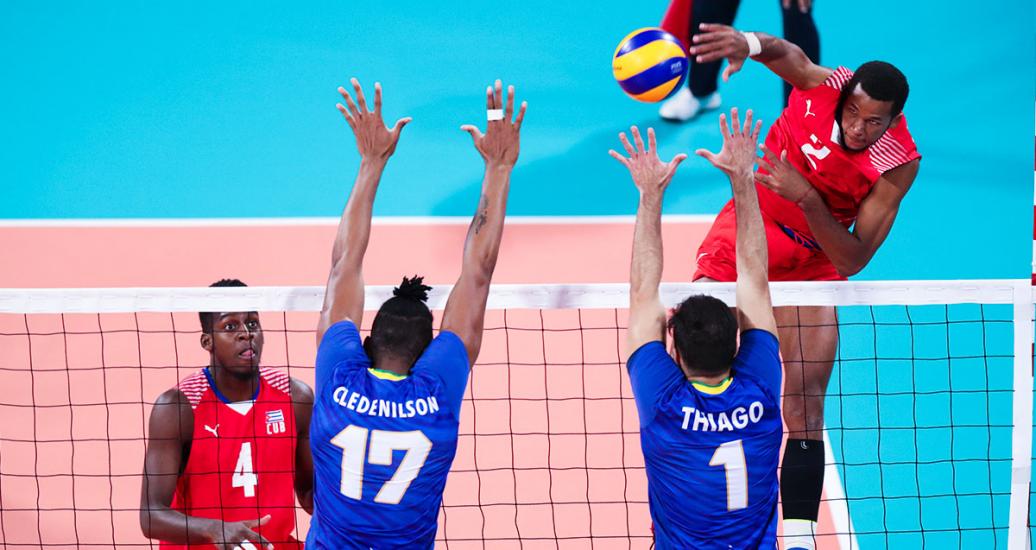 Cuban volleyball player Osniel Melgarejo spikes the ball against Brazilians during the Lima 2019 semifinal match at the Callao Regional Sports Village