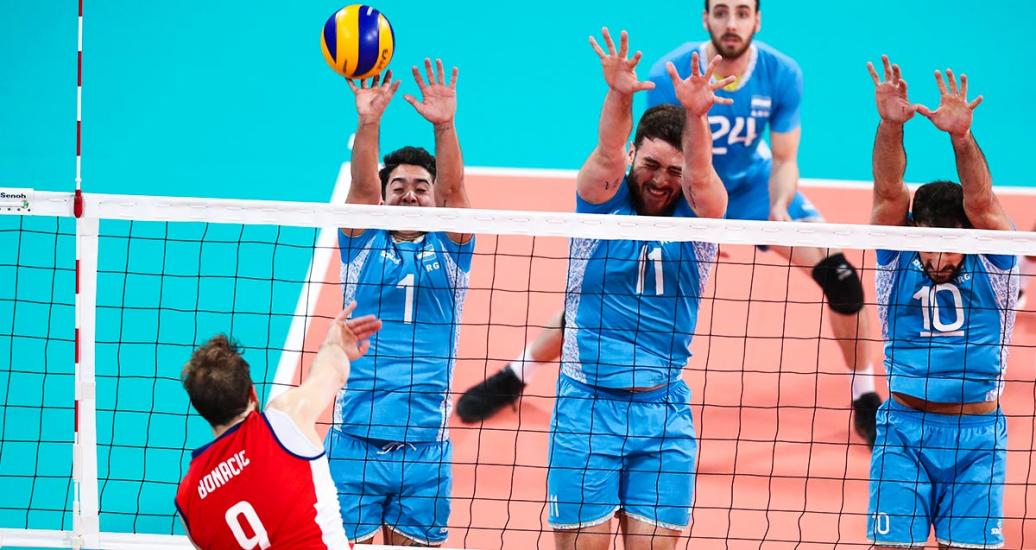 Argentinian volleyball players Matías Sánchez, Gastón Fernández and Bruno Nicólas trying to block the ball from Chilean Dusan Bonacic in the Lima 2019 semifinal match at the Callao Regional Sports Village