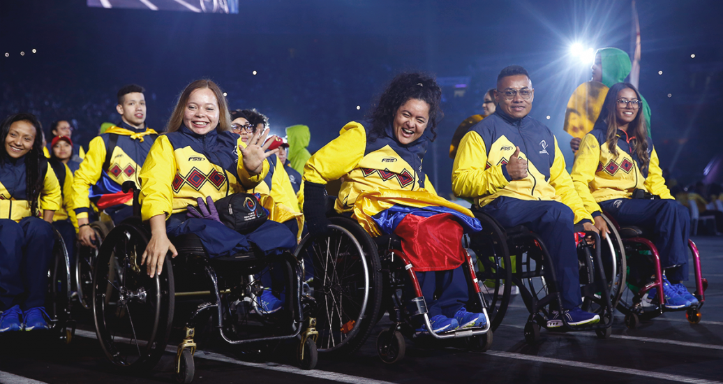 Colombian delegation carrying their national flag and waving at the camera at the Lima 2019 Parapan American Games Opening Ceremony at the National Stadium.