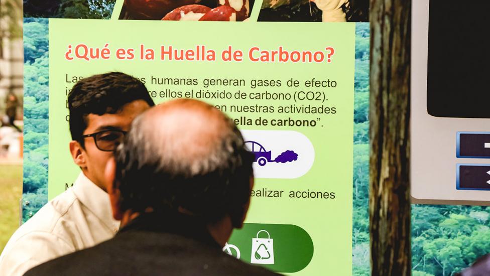 Hombre recibe información sobre la huella de carbono de parte de un voluntario de Sernanp durante los Juegos Lima 2019.